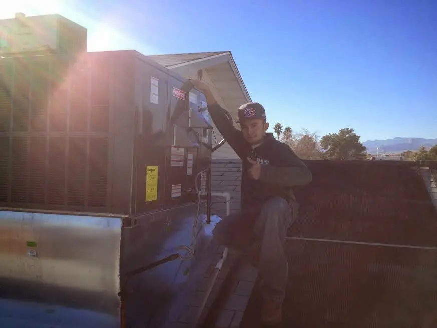 HVAC technician performing HVAC Inspection on a rooftop unit in Orland Hills